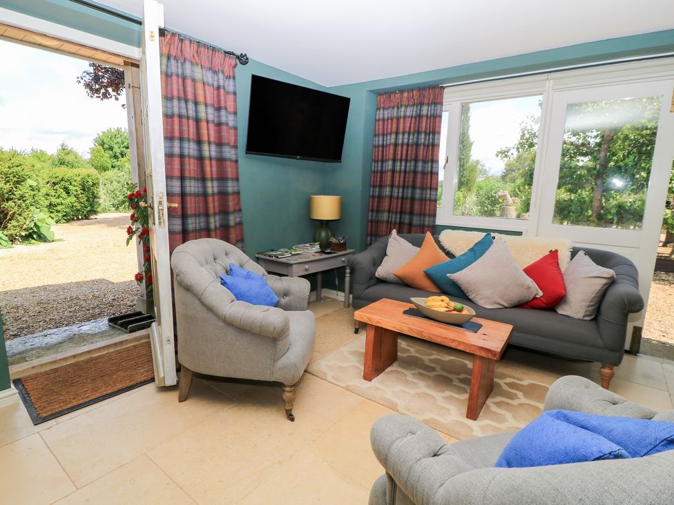 A living room with a sofa and armchair at Pudding Hill Barn Cottage Bibury