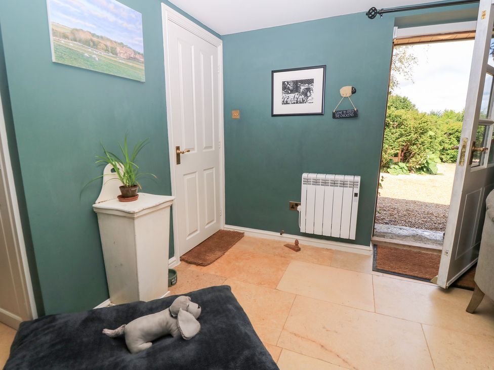 An entryway with a plant and a radiator at Pudding Hill Barn Cottage in Bibury