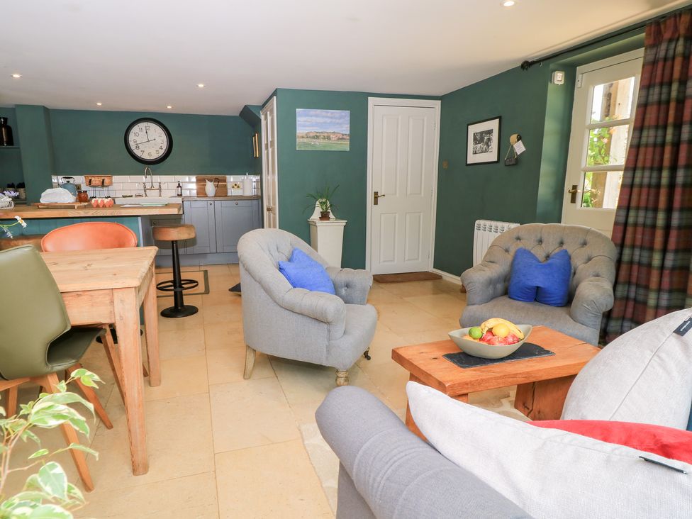 A kitchen with a dining table and chairs at Pudding Hill Barn Cottage Bibury