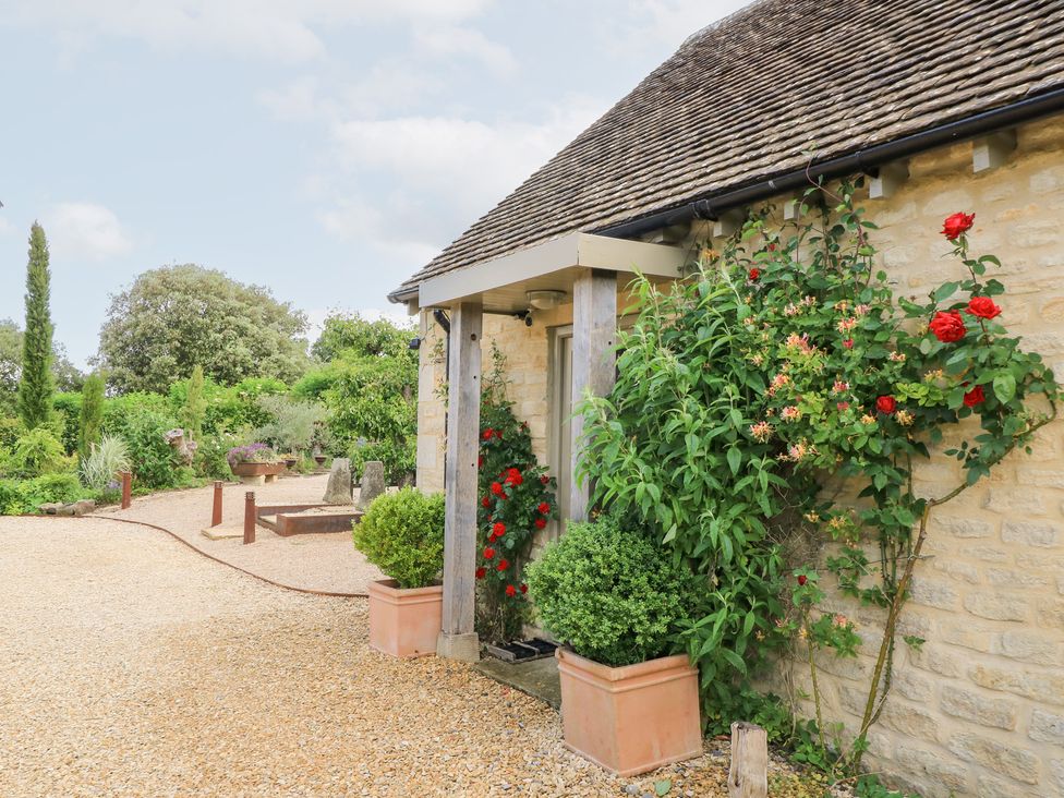 An outdoor area with a stone wall and plants at Pudding Hill Barn Cottage Bibury