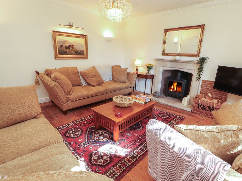 A living room with a fireplace and sofa at Garsdale Foot in Sedbergh