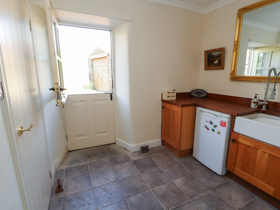 A kitchen with a fridge, sink, and counter at Garsdale Foot in Sedbergh