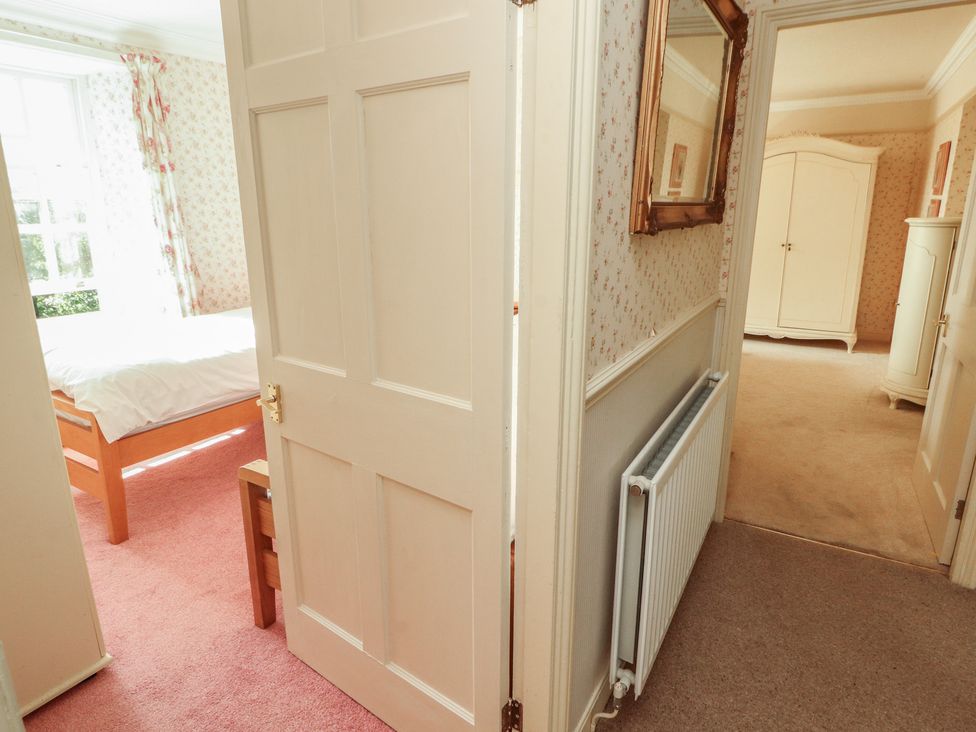 A bedroom with a bed and wardrobe at Garsdale Foot in Sedbergh
