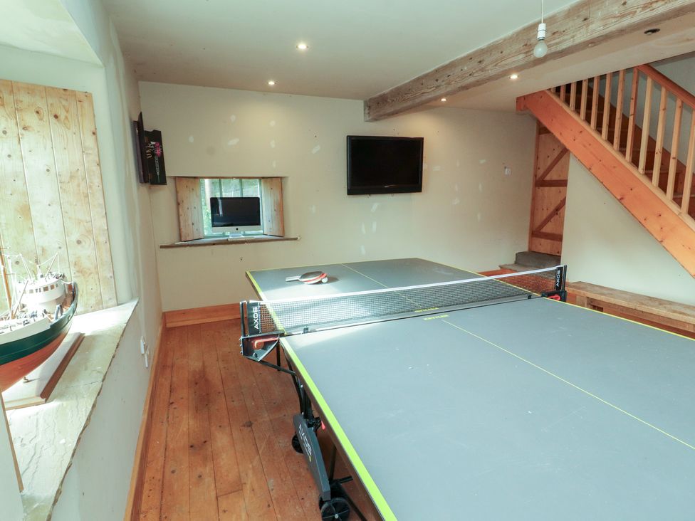 A game room with a ping pong table and a television at Garsdale Foot in Sedbergh
