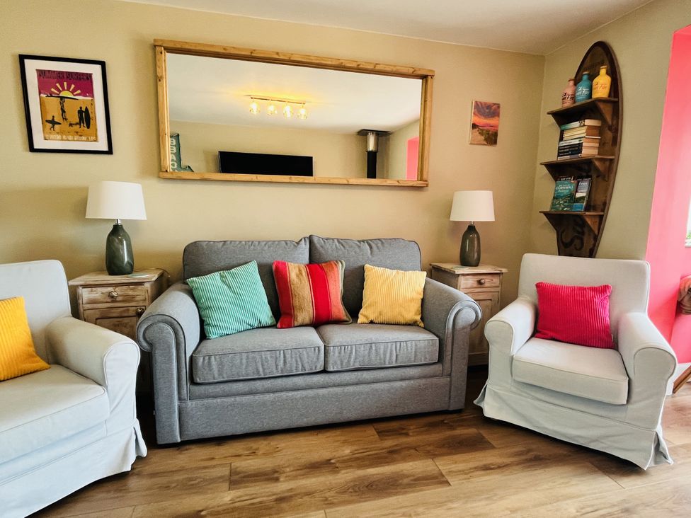 A living room with sofa and armchairs at Kippy Cottage in Truro