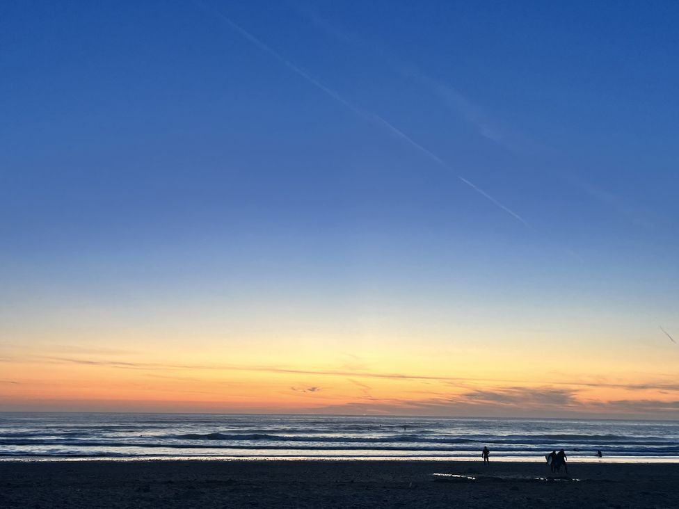 A beach with people during sunset at Kippy Cottage Truro