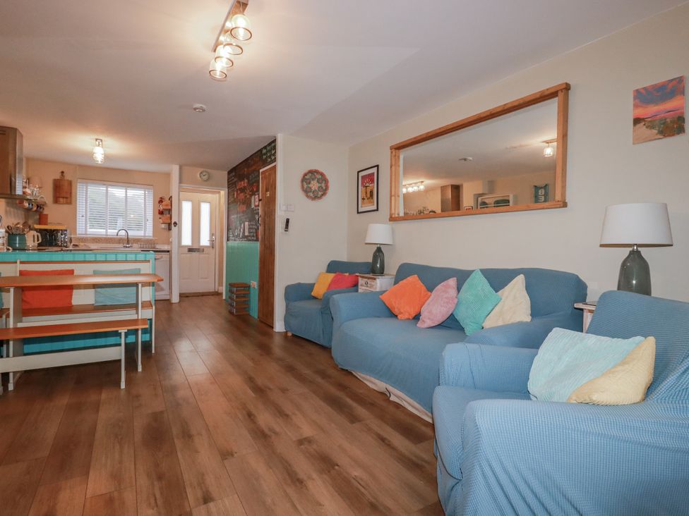 A living room with sofas and a table at Kippy Cottage in Porthtowan