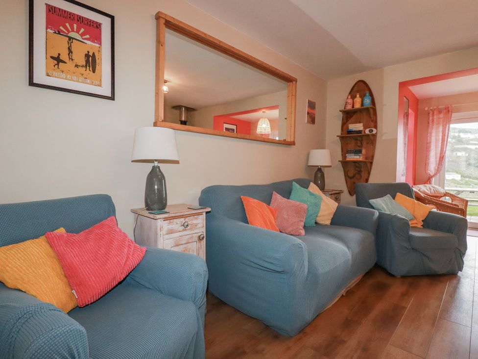A living room with sofas and a lamp at Kippy Cottage Porthtowan