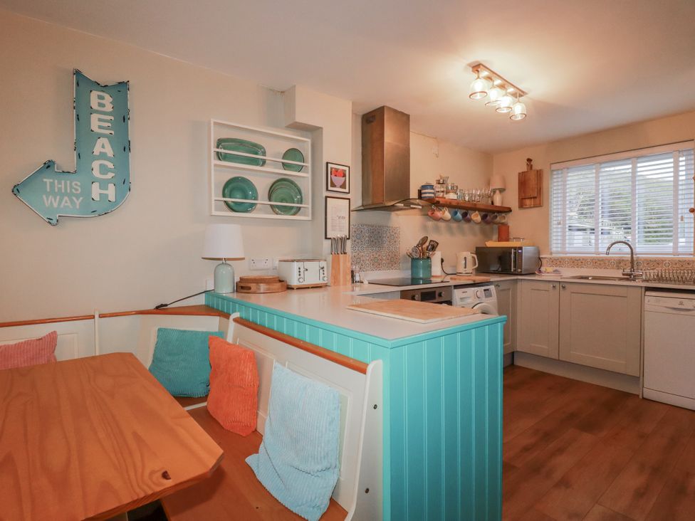 A kitchen with a table and appliances at Kippy Cottage Porthtowan