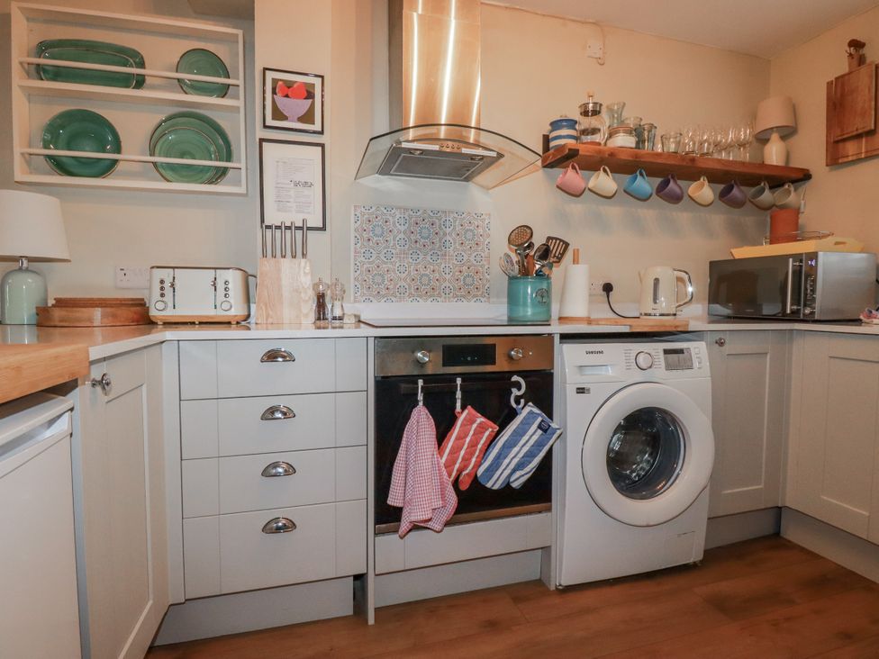 A kitchen with appliances and utensils at Kippy Cottage Porthtowan