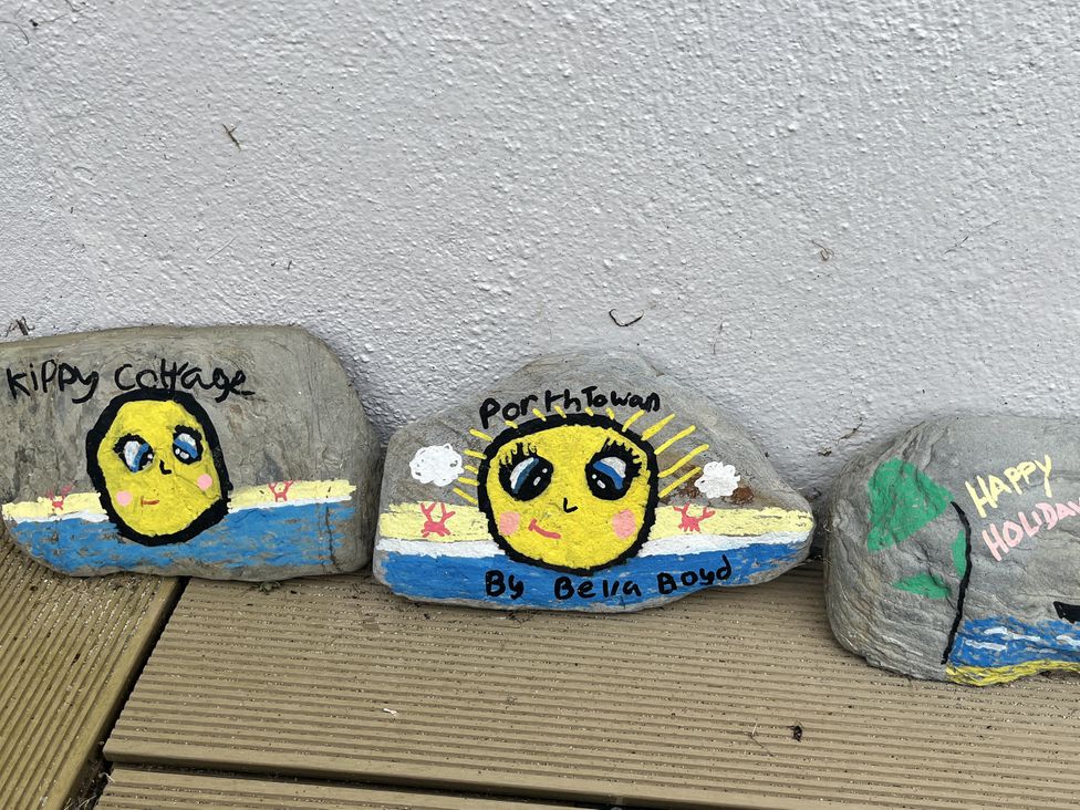 Painted rocks with beach scenes and text at Kippy Cottage Porthtowan