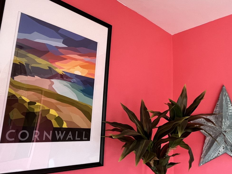 A picture frame with artwork and a plant at Kippy Cottage in Porthtowan