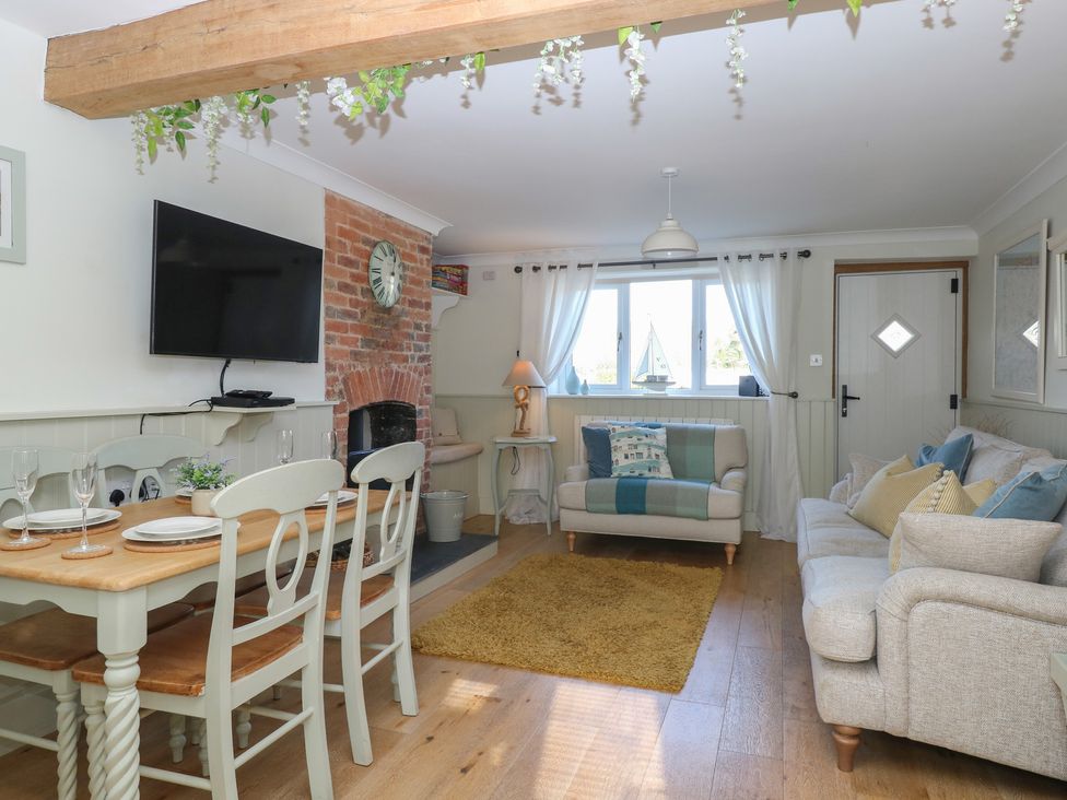 A living room with a dining table and chairs at Herbies Cottage in Snettisham
