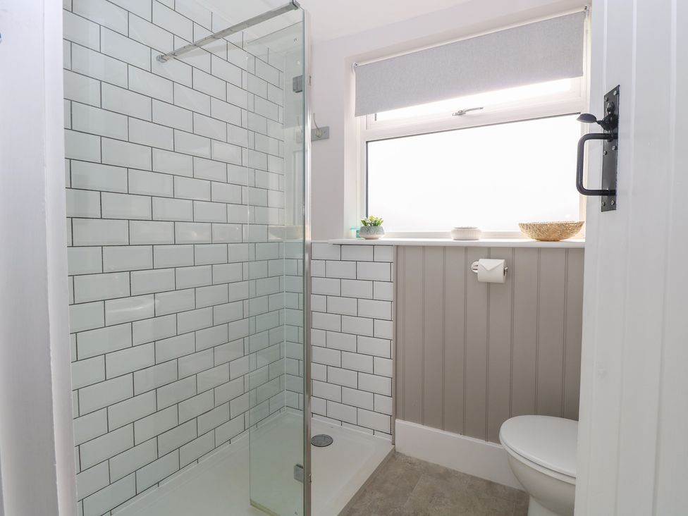 A bathroom with a shower, toilet and sink at Herbies Cottage Snettisham