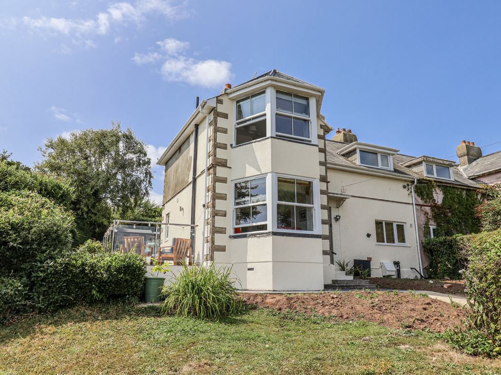 A house with a garden and patio furniture at St Helena in Charmouth