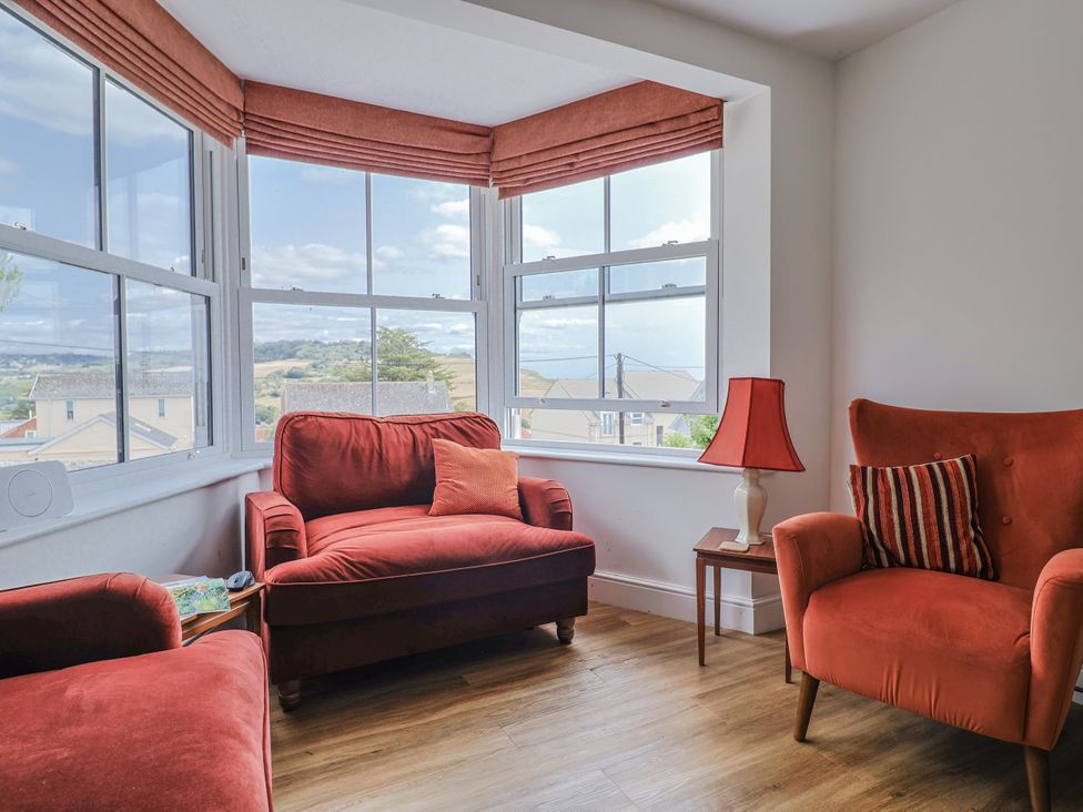 A snug with two armchairs and a table at St Helena in Charmouth