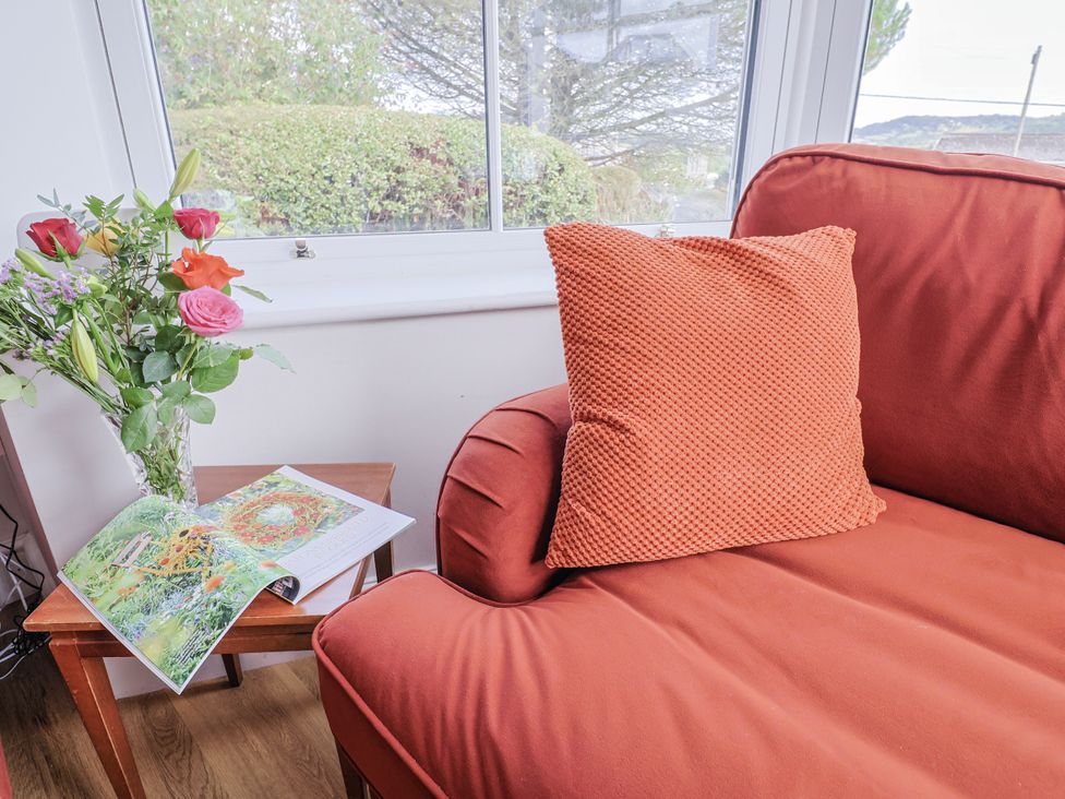 A living room with a couch and a flower vase at St Helena in Charmouth