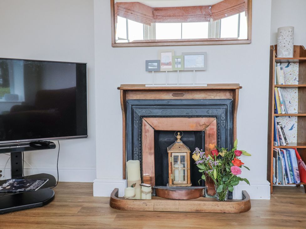 A living room with a fireplace and television at St Helena in Charmouth