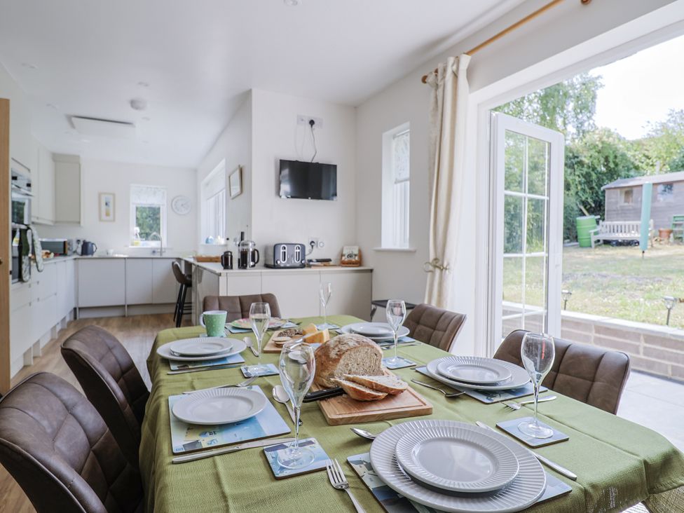 A kitchen with a dining table set for a meal at St Helena in Charmouth