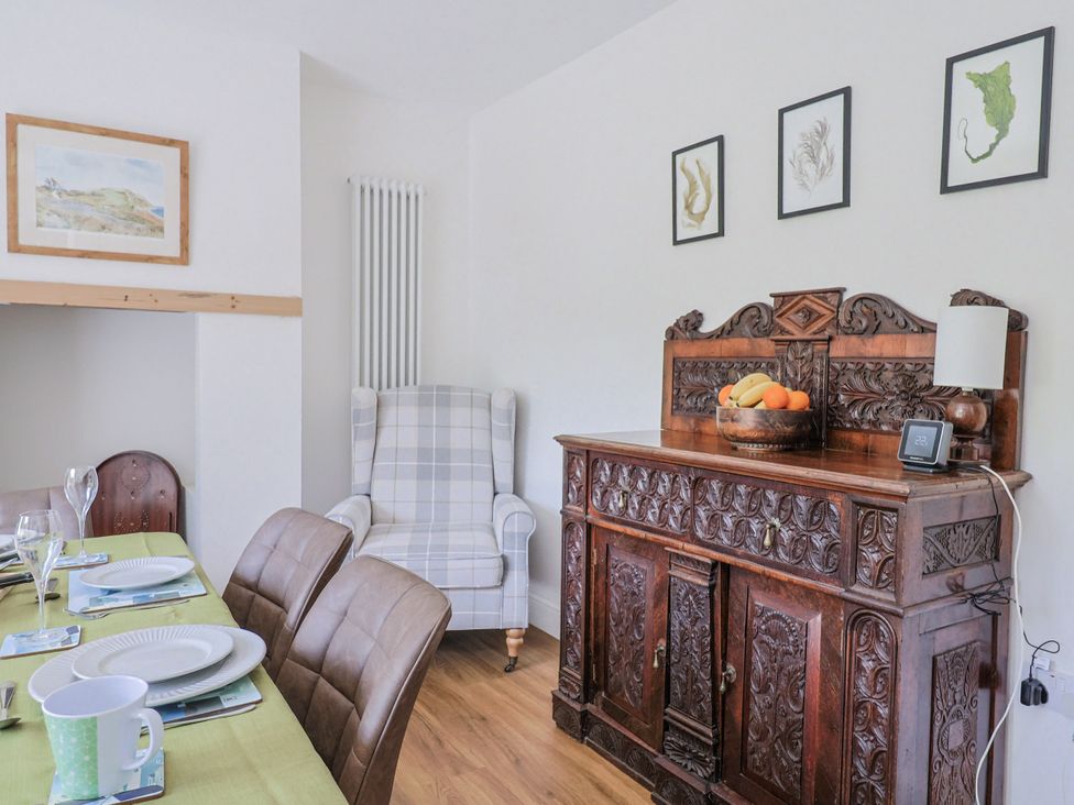 A dining room with a sideboard and dining table at St Helena in Charmouth