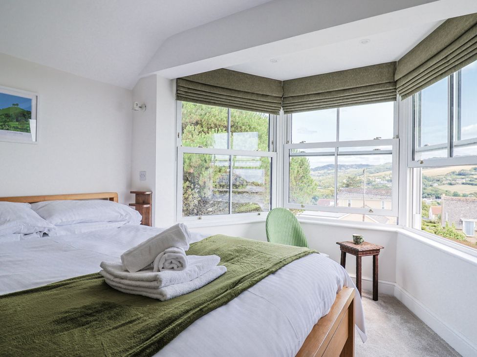 A bedroom with a bed and window view at St Helena in Charmouth