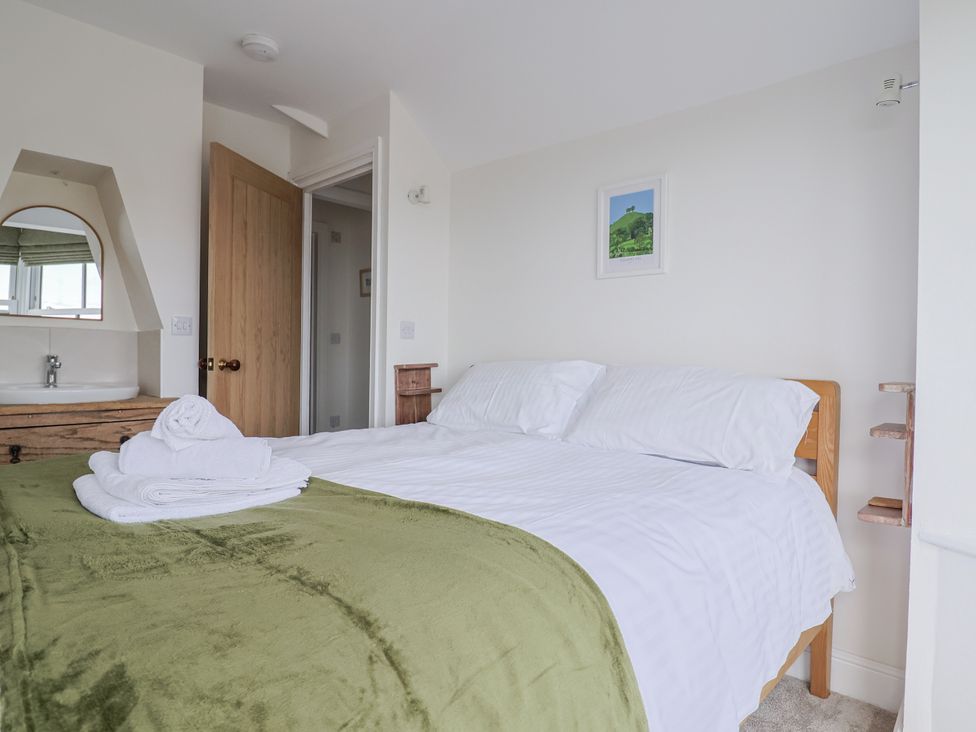 A bedroom with a bed and towels at St Helena in Charmouth