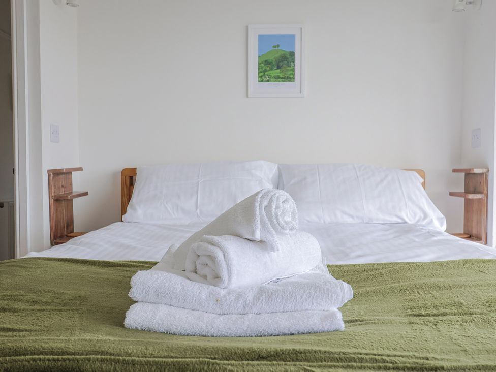 A bedroom with a bed and towels arranged at St Helena in Charmouth