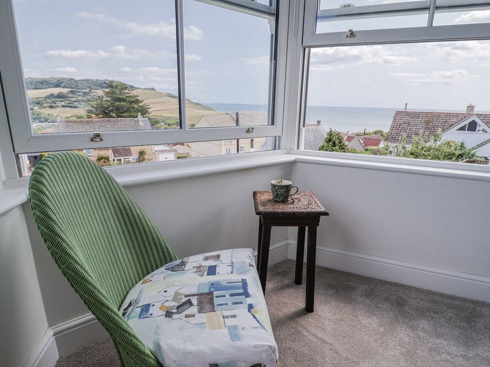 A snug with a chair and table overlooking the sea at St Helena in Charmouth