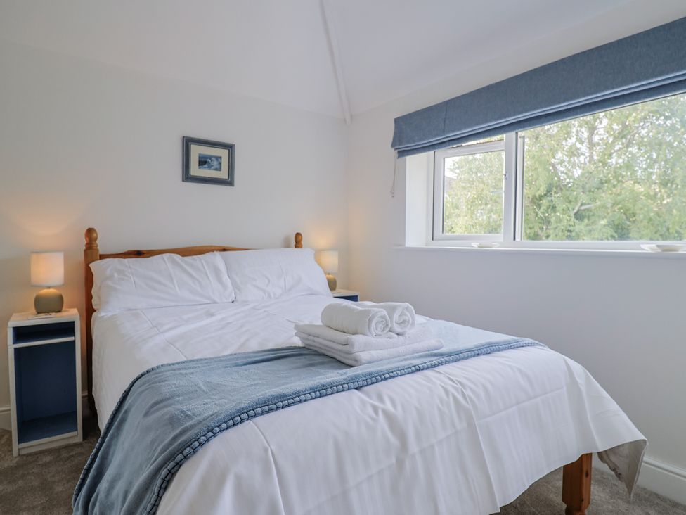 A bedroom with a bed and bedside tables at St Helena in Charmouth