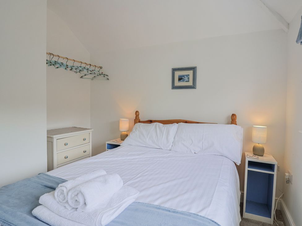 A bedroom with a bed and nightstands at St Helena in Charmouth