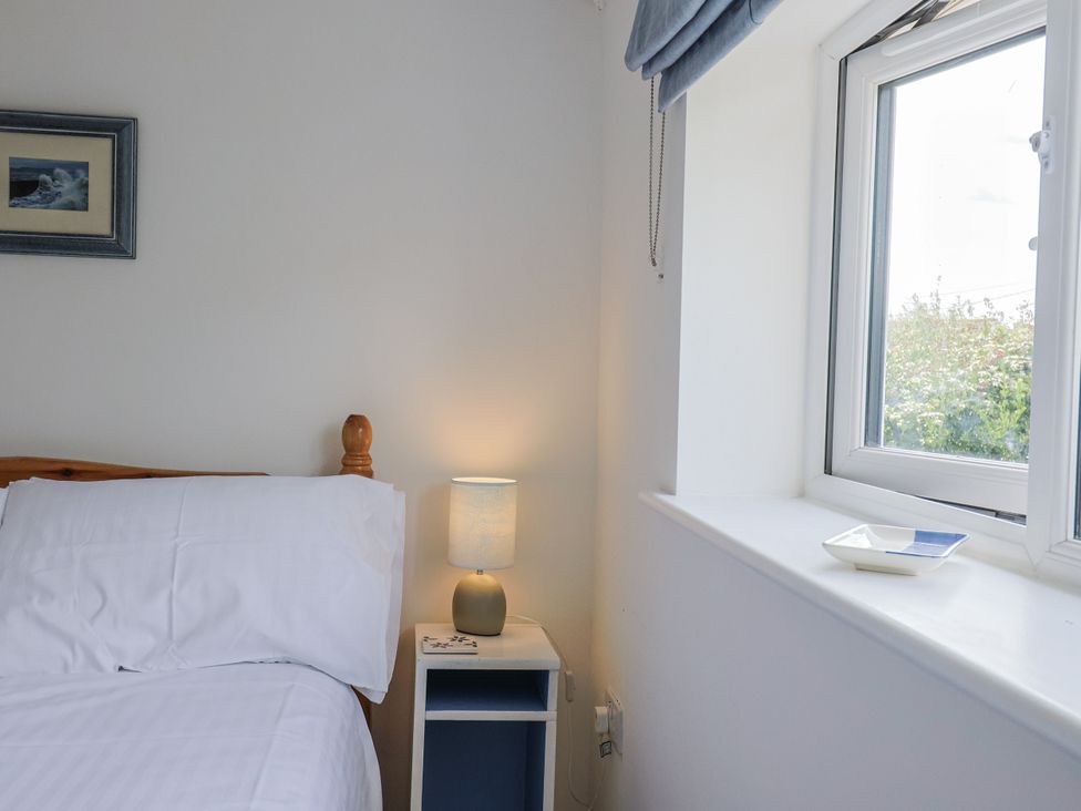 A bedroom with a bed and lamp at St Helena in Charmouth