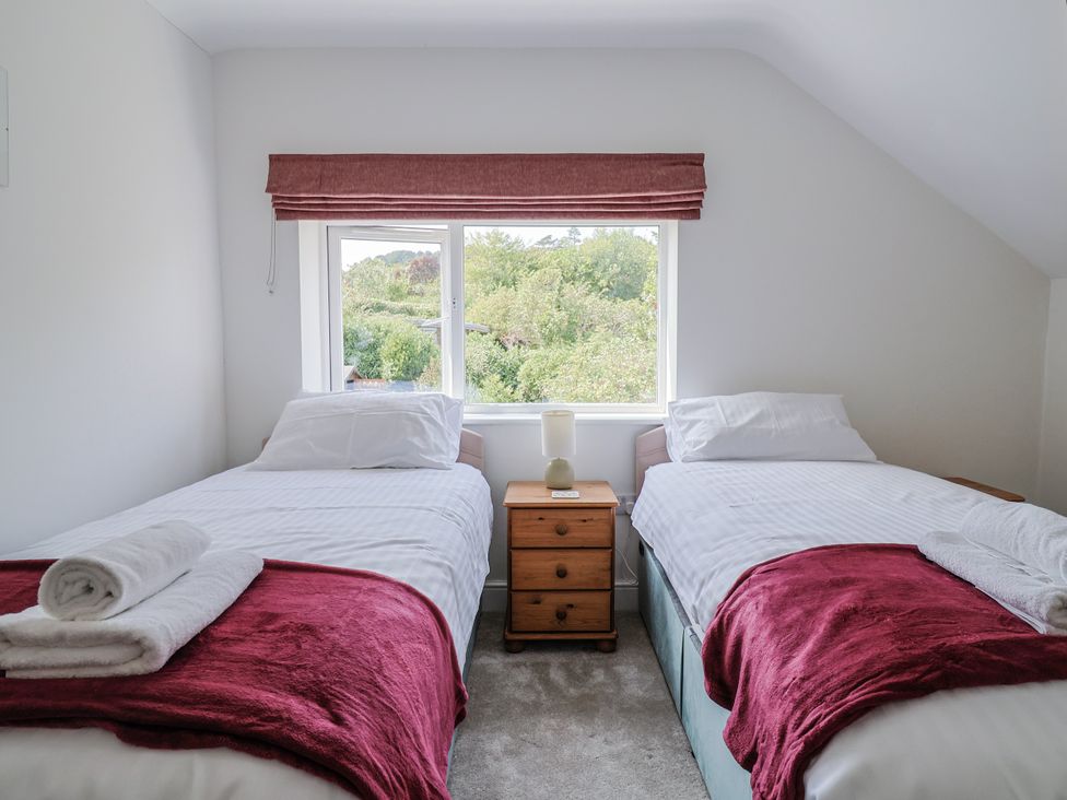 A bedroom with two single beds and a window at St Helena in Charmouth