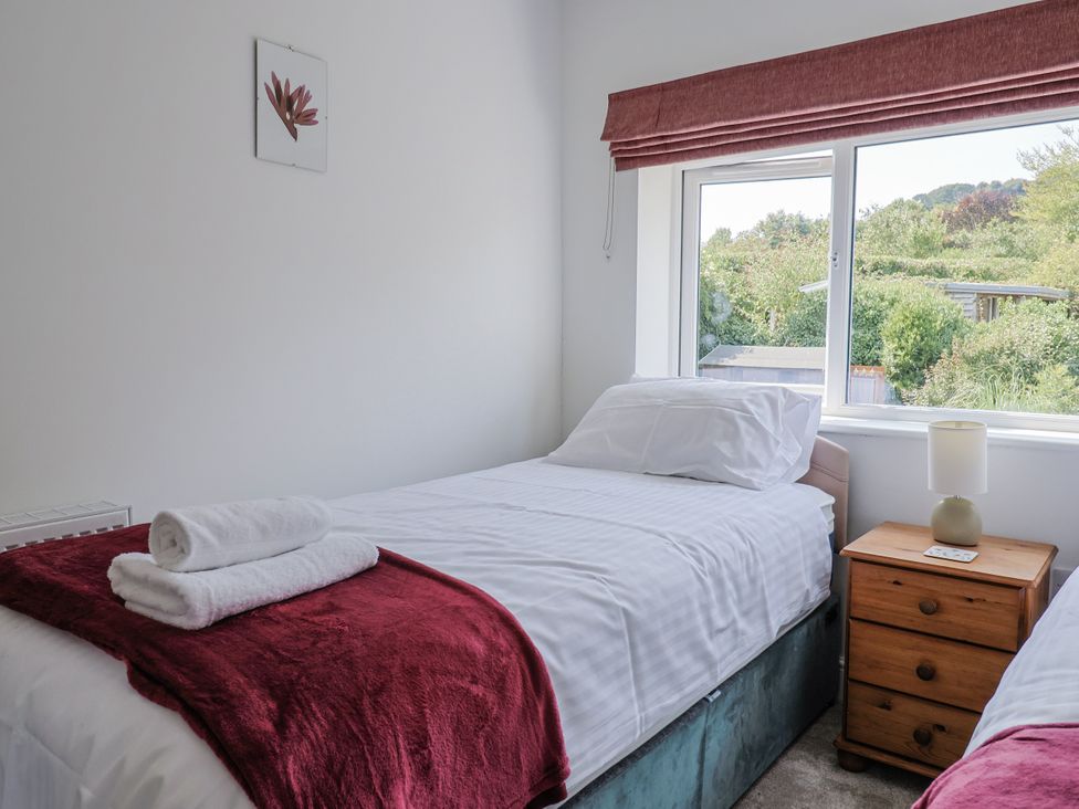 A bedroom with two beds and a window at St Helena in Charmouth