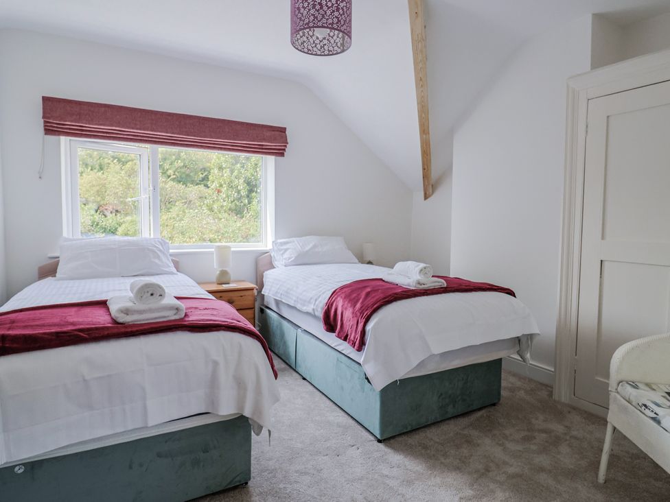 A bedroom with two beds and a window at St Helena in Charmouth