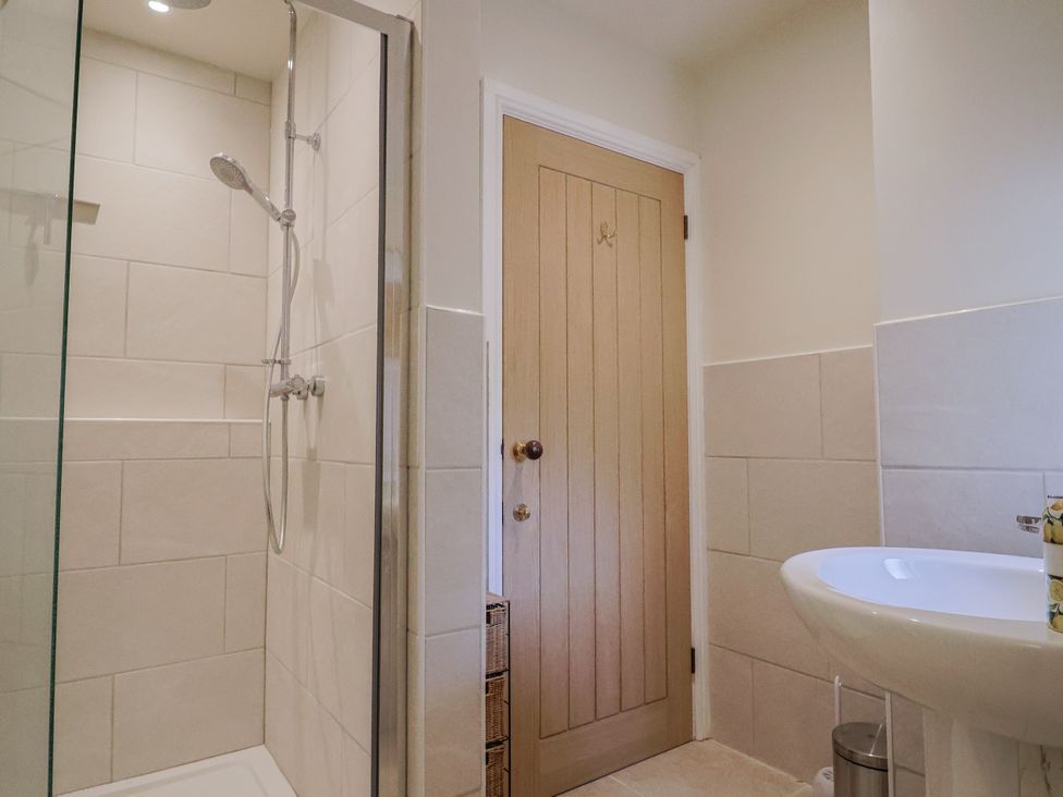 A bathroom with a shower and sink at St Helena in Charmouth