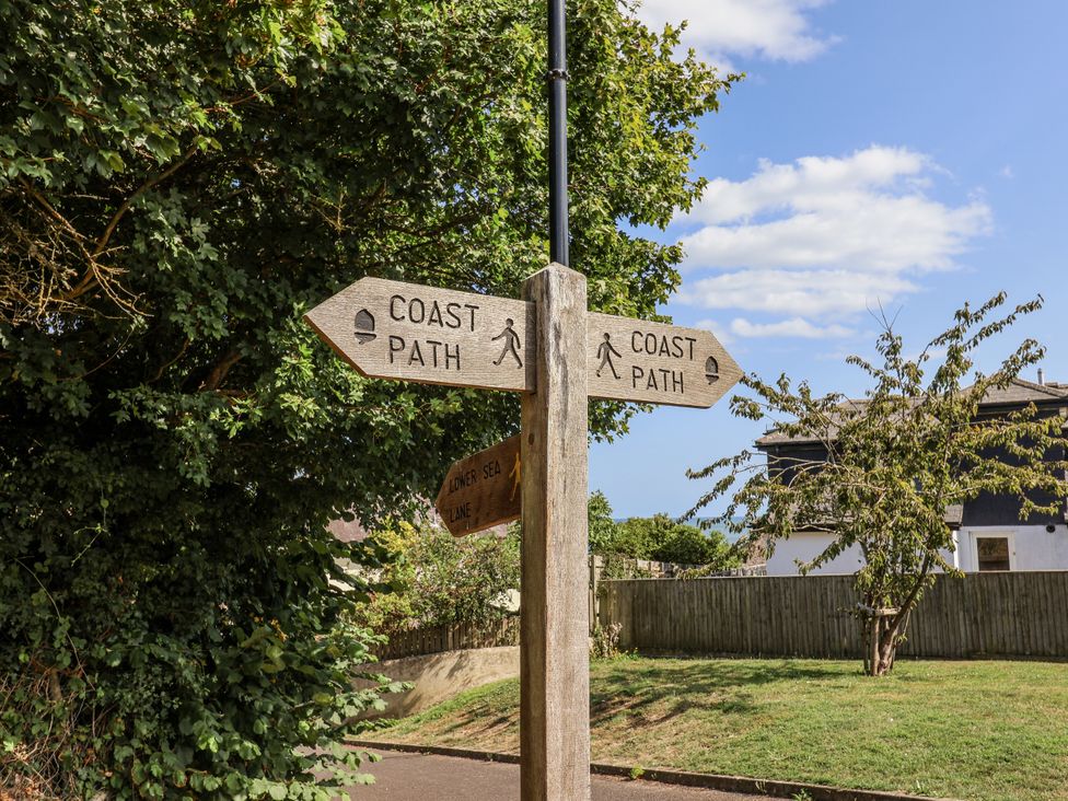 A signpost indicating coast path directions at St Helena in Charmouth