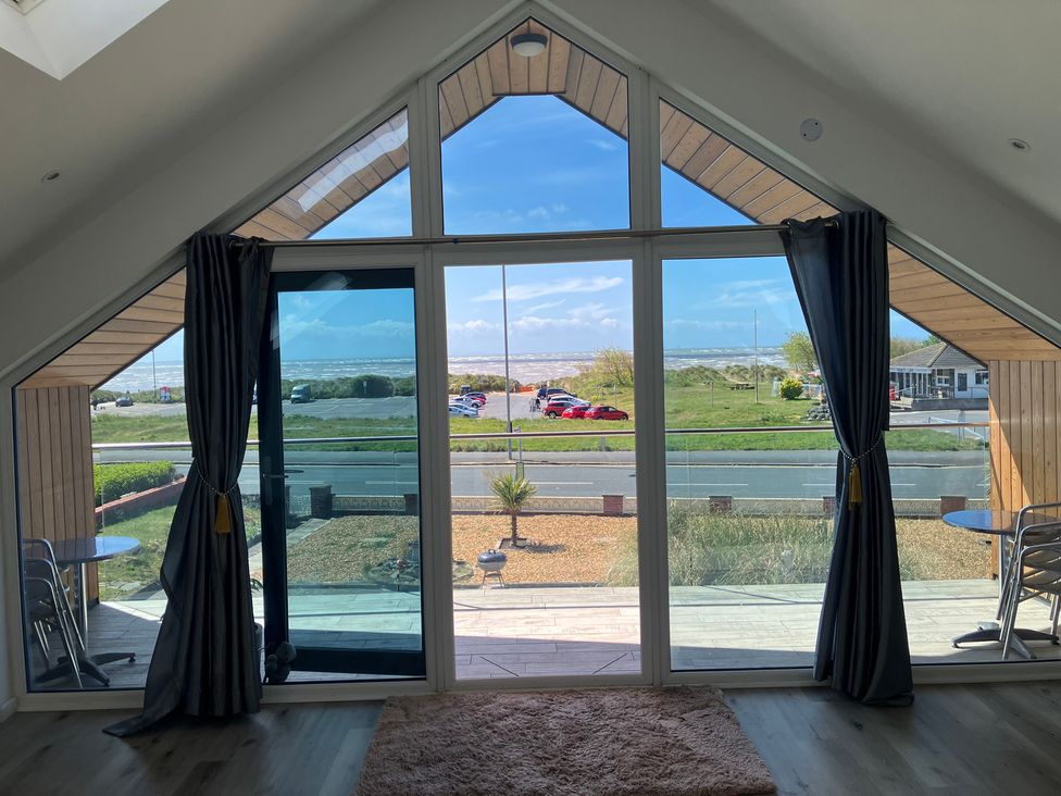 A living room view with windows and outdoor seating at Sea La Vie in Lytham St. Annes