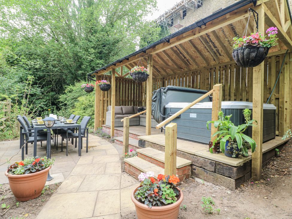A garden with a hot tub and dining area at Mill View Duplex in Cuckney