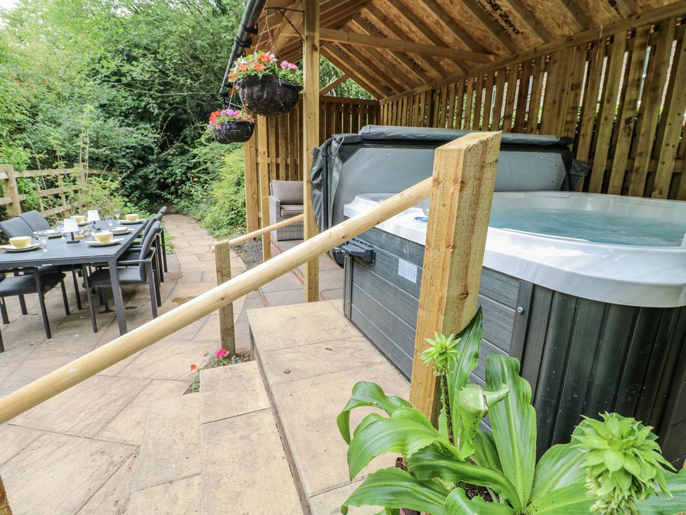 An outdoor garden with a hot tub and seating area at Mill View Duplex in Cuckney