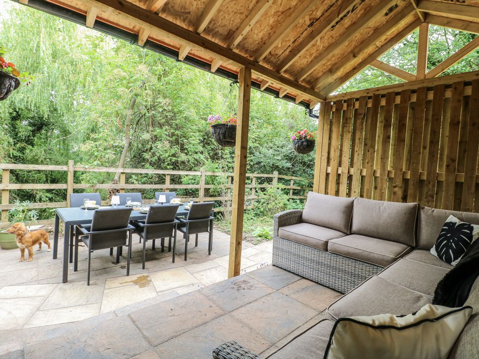 An outdoor seating area with a sofa and dining table at Mill View Duplex in Cuckney