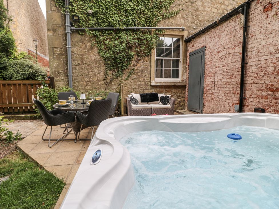 An outdoor area with a hot tub and furniture at Cotton Mill Cottage in Cuckney