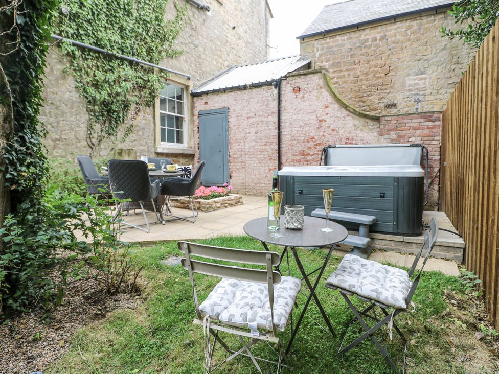 A garden with a hot tub and outdoor furniture at Cotton Mill Cottage in Cuckney