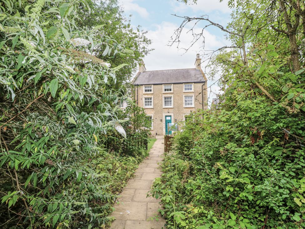 A path leading to a house surrounded by plants at Cotton Mill Cottage in Cuckney