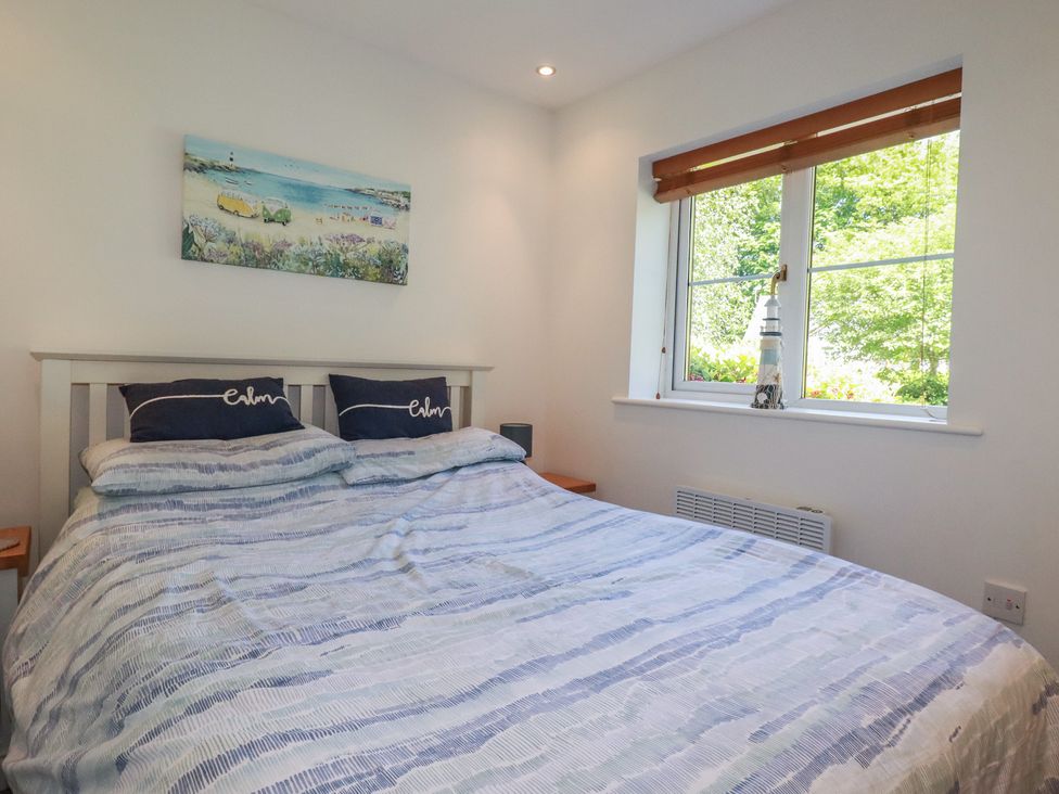 A bedroom with a bed and window at Lilyvale in Davidstow near Camelford
