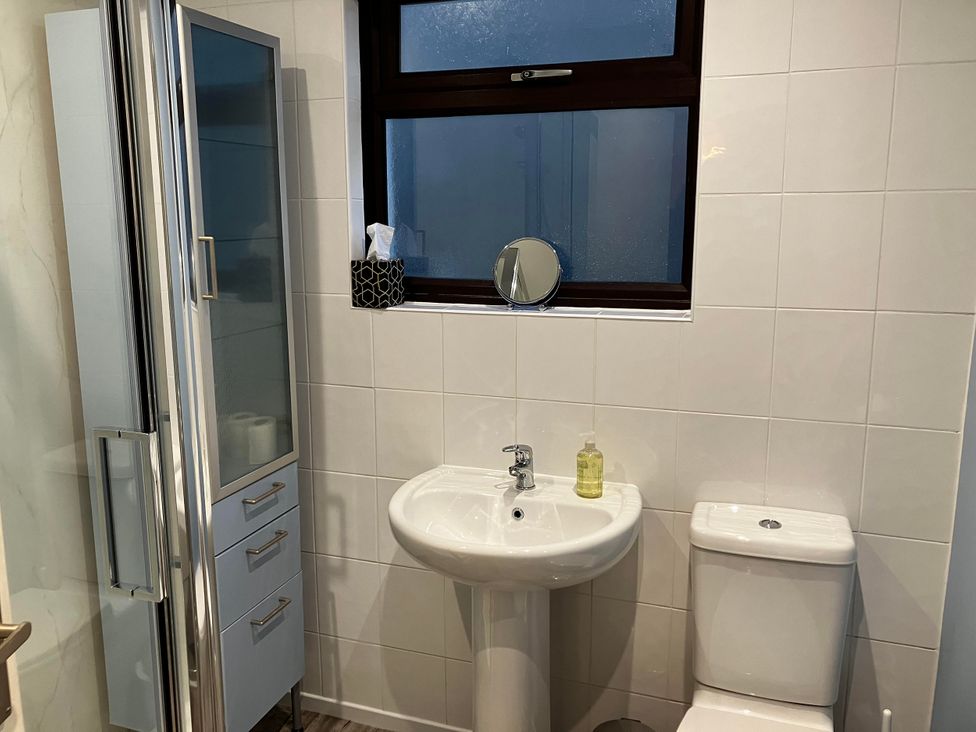 A bathroom with a shower, sink, and toilet at Marsh Garth in Kirkby-In-Furness