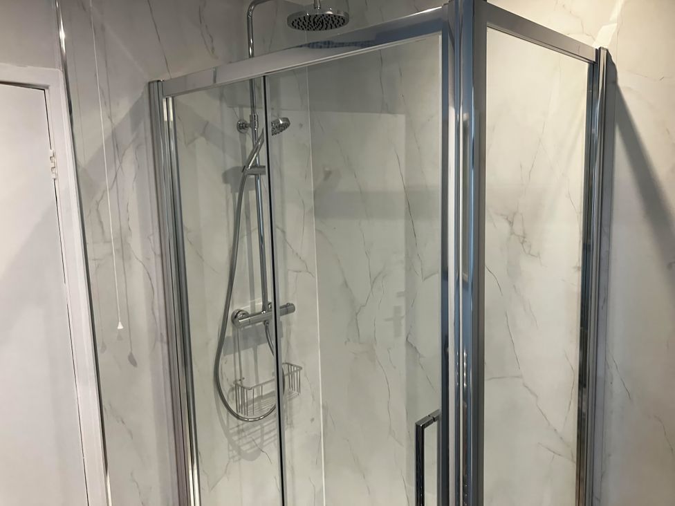 A shower enclosure with a glass door and wall at Marsh Garth in Kirkby-In-Furness