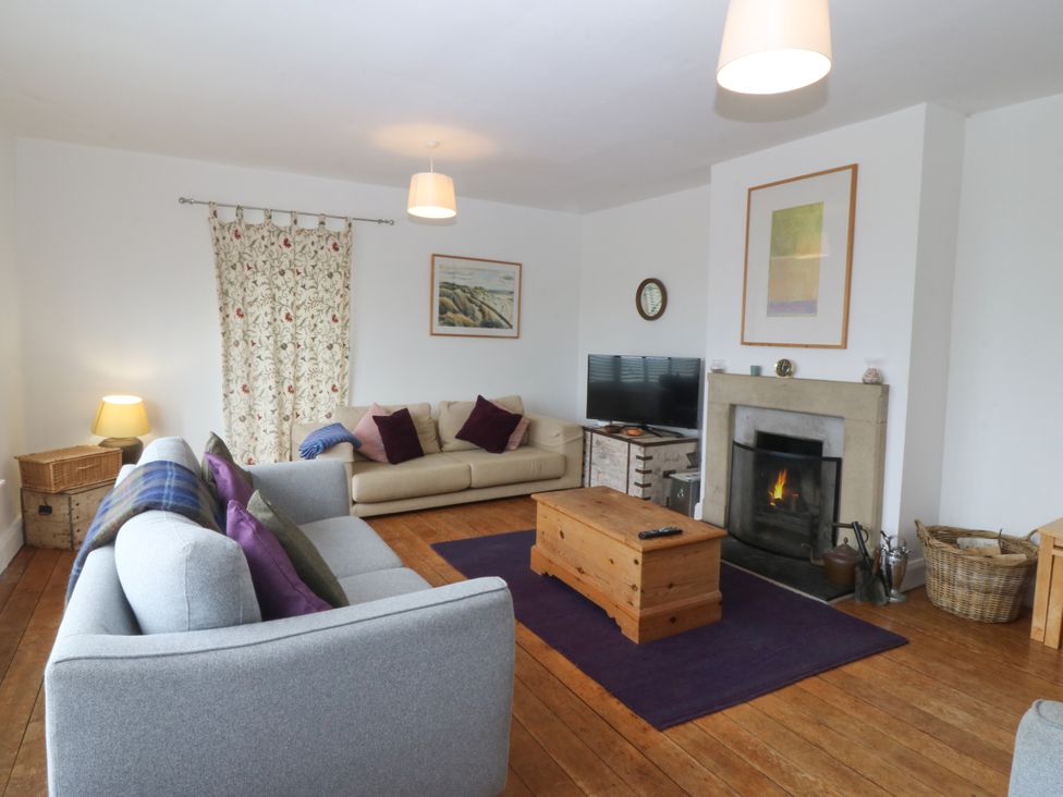 A living room with sofas and a fireplace at Faraway in Rhosneigr