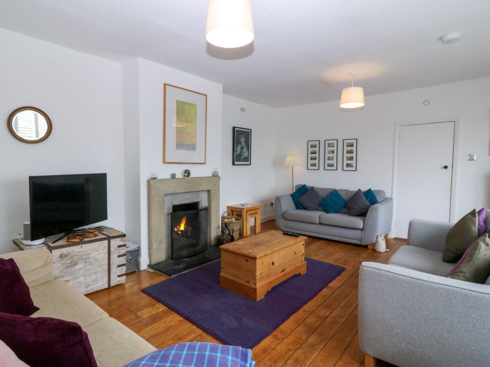 A living room with a fireplace and sofas at Faraway in Rhosneigr