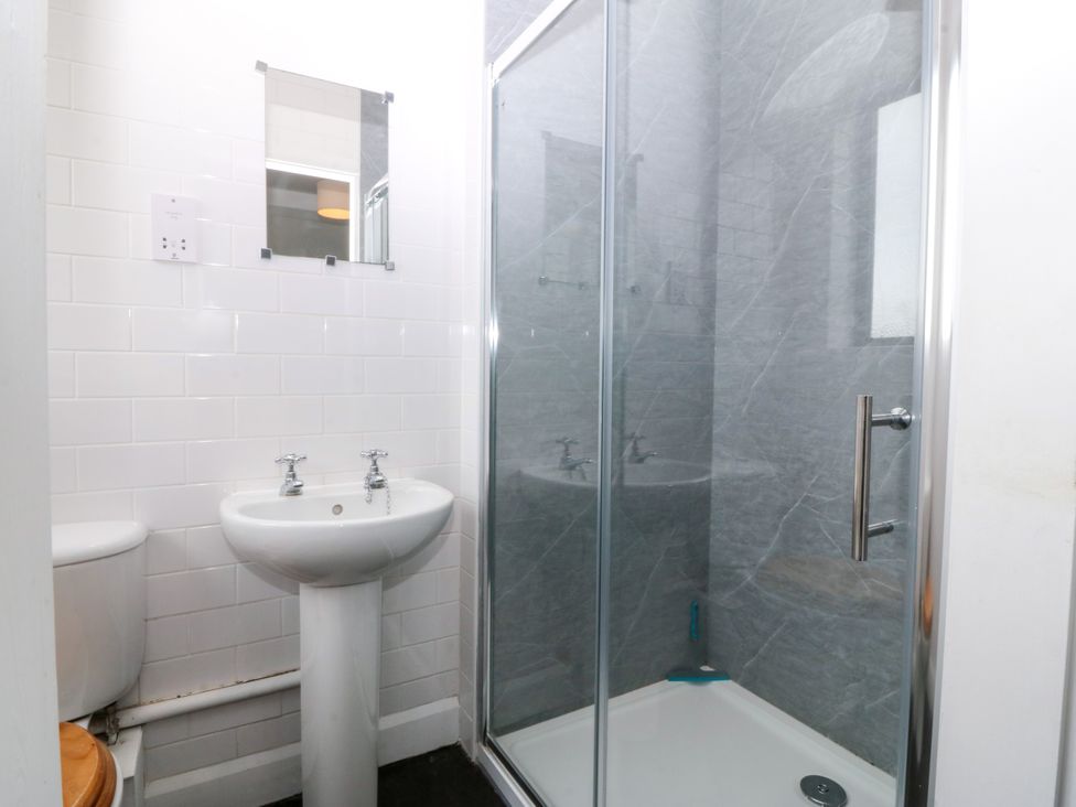 A bathroom with a shower, sink, and toilet at Faraway, Rhosneigr