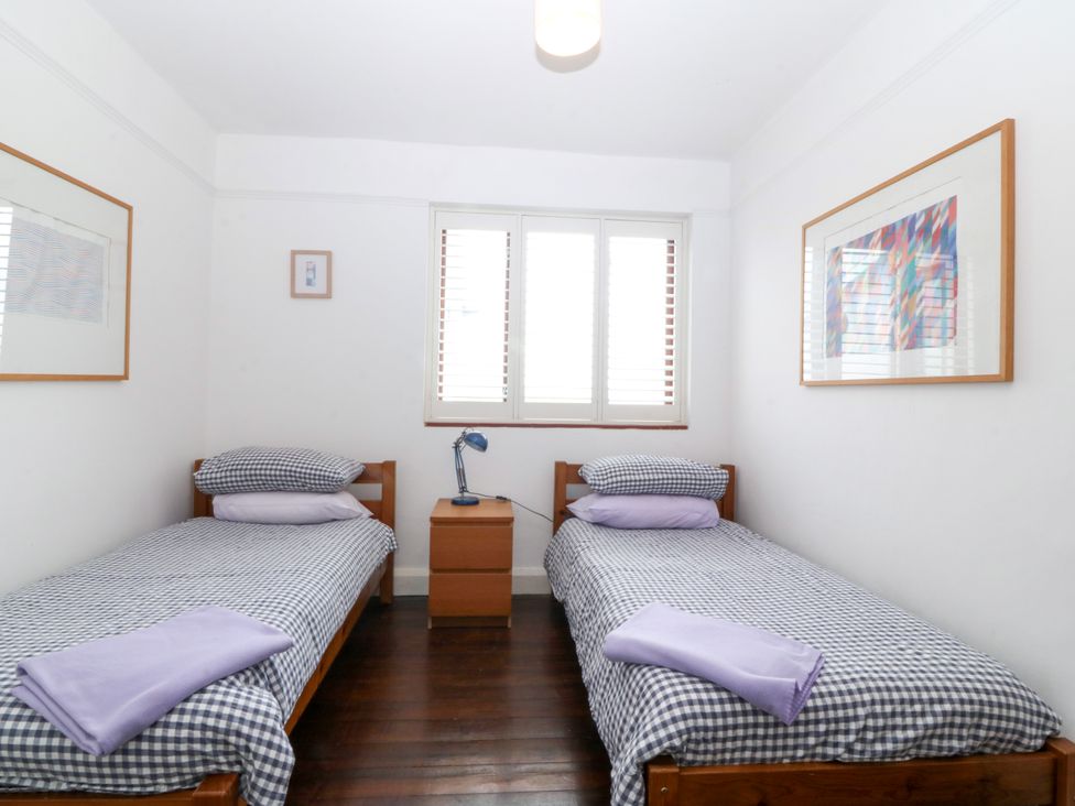 A bedroom with two single beds and a bedside table at Faraway in Rhosneigr